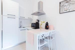 a kitchen with white cabinets and a white island at Little Fish studio in Rijeka +18 photos