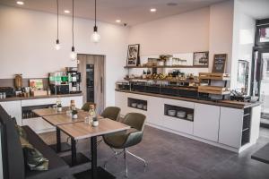 a restaurant with tables and chairs and a counter at Hayta Hotel Stuttgart Airport Messe in Filderstadt