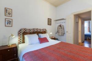 a bedroom with a large bed with a red blanket at 2 bedroom apartment with patio next to Avenida da Liberdade in Lisbon