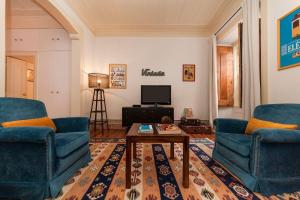 a living room with two blue chairs and a coffee table at 2 bedroom apartment with patio next to Avenida da Liberdade in Lisbon