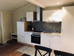 a kitchen with white cabinets and a sink at Apartments in Svarte in Ystad