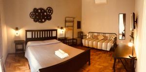 a bedroom with two beds and a couch at Stazione22 B&B in Pisa