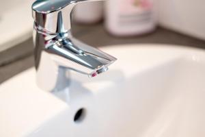 a sink with a faucet on a white sink at Ferienhaus Lorea Bütgenbach in Butgenbach