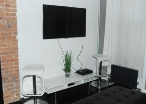 escritorio blanco con 2 sillas y TV en la pared en Plush Spacious 1 bedroom apt Williamsburg, en Brooklyn