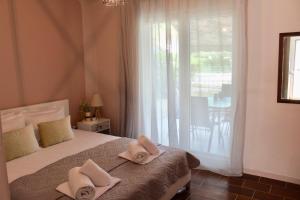 a bedroom with a bed with two towels on it at Anemos Apartment Palio in Paleo Tsifliki