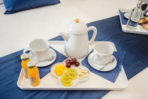 ein Tablett mit einem Tee-Set mit Obst darauf in der Unterkunft Kerbaker 14 in Neapel