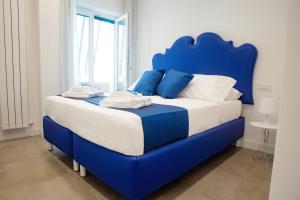 Cama azul con sábanas blancas y almohadas azules en Kerbaker 14 en Nápoles