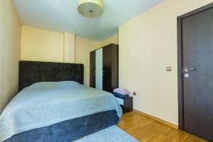 a bedroom with a large bed with a blue blanket at Este apart 5 - Top center in Sofia