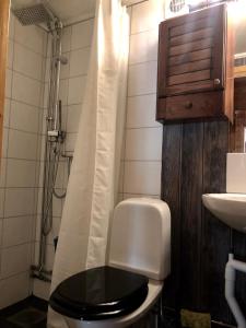 a bathroom with a toilet with a black seat and a sink at Lillstugan in Sälen