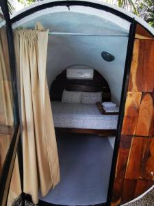 una piccola tenda con un letto all'interno. di Kulu Tubohostel Bacalar a Bacalar