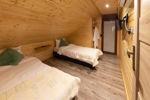 ボシュコボにあるOW Magdalenaの木造キャビン内のベッドルーム1室(ベッド2台付)