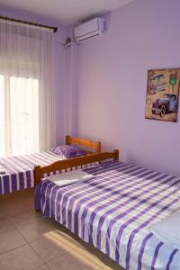 a bedroom with two beds and a window at Apartments Anesis Pantazis in Asprovalta