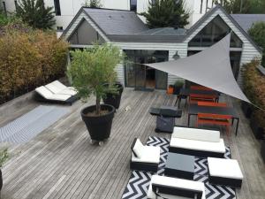 un patio con sillas y un árbol en maceta en una terraza en Maison contemporaine Centre DEAUVILLE - " 3 NUITS MINIMUM" en Deauville