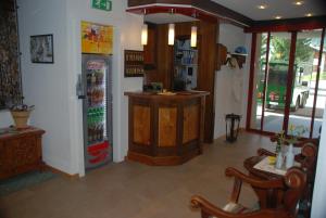 a room with a refrigerator and a table and chairs at Hotel Garni Jägerhof in Saas-Fee