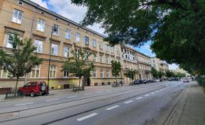 an empty street in front of a large building at Gertrudy Old Town Apartments in Kraków