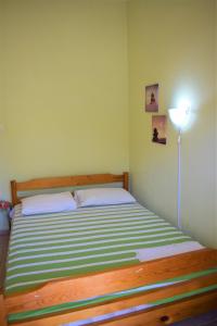アスプロヴァルタにあるApartments Anesis Pantazisのベッドルーム1室(緑と白のストライプのマットレス付きのベッド1台付)