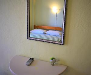 アスプロヴァルタにあるApartments Anesis Pantazisのバスルーム(洗面台の上に鏡付)、ベッド1台が備わります。
