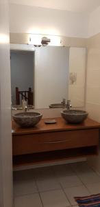 two sinks in a bathroom with two mirrors at Villa d'Alys in Sainte-Rose