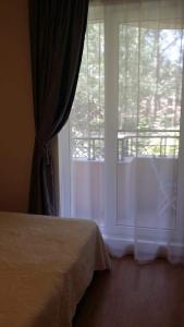 a bedroom with a bed and a window with a balcony at Апартаменты Aphrodite Roce in Sunny Beach +13 photos