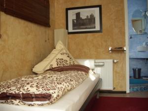 ein Schlafzimmer mit einem Bett mit einem Kissen darauf in der Unterkunft Fritzis Art Hotel in Filderstadt
