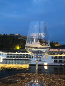 ein Glas Wein auf einem Tisch mit einem Kreuzfahrtschiff in der Unterkunft Humboldtruh in Weitersburg