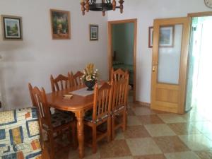 una sala da pranzo con tavolo e sedie in legno di Adosado Karivu Patera a La Antilla