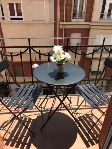 una mesa y sillas en un balcón con un jarrón de flores en Apartamentos Logroño centro, TIC TAC, wifi, en Logroño