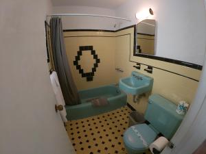 bagno con servizi igienici blu e lavandino di Sea Chest Motel a Wildwood Crest