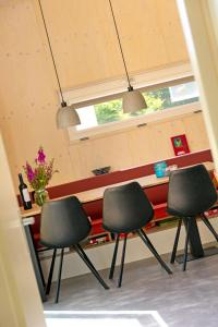 trois chaises devant un comptoir dans une pièce dans l'établissement De Lepelaar, à Midsland