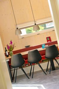 three chairs in front of a counter in a room at De Lepelaar in Midsland