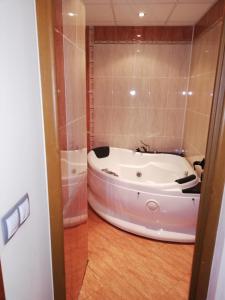 a bath tub in a bathroom with a shower at Комплекс Рожена, хотел, хотелски комплекс Рожена in Rozhen