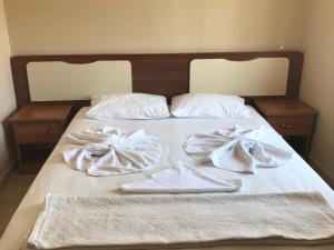 a bed with white sheets and towels on it at Serendi Apart Hotel in Alanya