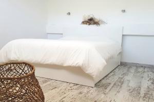 a bedroom with a white bed and a basket at Lugar de la Luz in Estepona