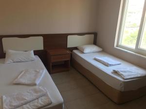 two beds in a room with two windows at Serendi Apart Hotel in Alanya