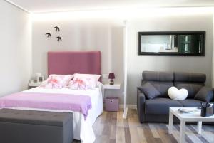 sypialnia z łóżkiem i kanapą w obiekcie Acio Tinto Loft Casco Histórico de Ourense w mieście Ourense