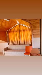 アランヤにあるSerendi Apart Hotelのベッドルーム1室(ベッド1台、オレンジの椅子付)