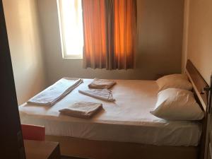 a bed with two towels on it with a window at Serendi Apart Hotel in Alanya