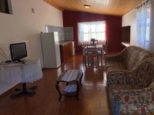 een woonkamer met een bank en een tafel met een tv bij Quinta da quebrada in Santana