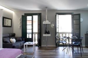 een woonkamer met een bank en een tafel met stoelen bij Acio Tinto Loft Casco Histórico de Ourense in Ourense