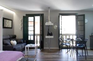 salon z kanapą i stołem z krzesłami w obiekcie Acio Tinto Loft Casco Histórico de Ourense w mieście Ourense