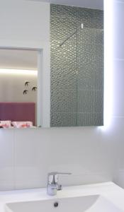 zlew w łazience z lustrem nad umywalką w obiekcie Acio Tinto Loft Casco Histórico de Ourense w mieście Ourense +2 zdjęcia