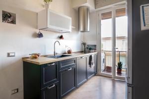a kitchen with black and white cabinets and a window at Via Pai Home a due passi da Firenze in Scandicci