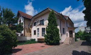 una casa con un árbol delante en Flora Luxury House, en Sighişoara