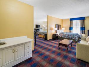 a hotel room with a bed and a couch at Americas Best Value Inn - Clayton in Clayton