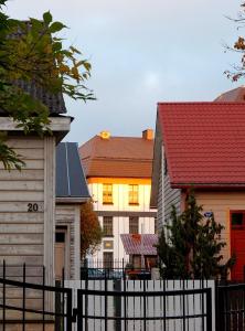 a group of houses with a fence and a house with a red roof at Quiet Romantic Studio plus parking, Tartu Home in Tartu