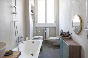 La salle de bains est pourvue d'une baignoire, de toilettes et d'un lavabo. dans l'établissement Via Pai Home a due passi da Firenze, à Scandicci