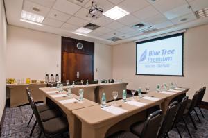a conference room with a long table and a screen at Blue Tree Premium Faria Lima in Sao Paulo
