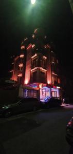 ein Gebäude mit einem Auto, das nachts davor geparkt ist in der Unterkunft Sofia Family Hotel in Pomorie