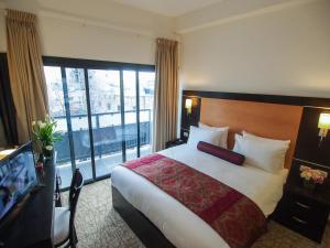 a hotel room with a bed and a large window at New Capitol Hotel - Jerusalem in Jerusalem
