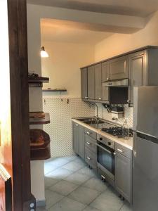 a kitchen with gray cabinets and a stove top oven at Casa Santicelli Maratea ' I CARPINI ' in Maratea